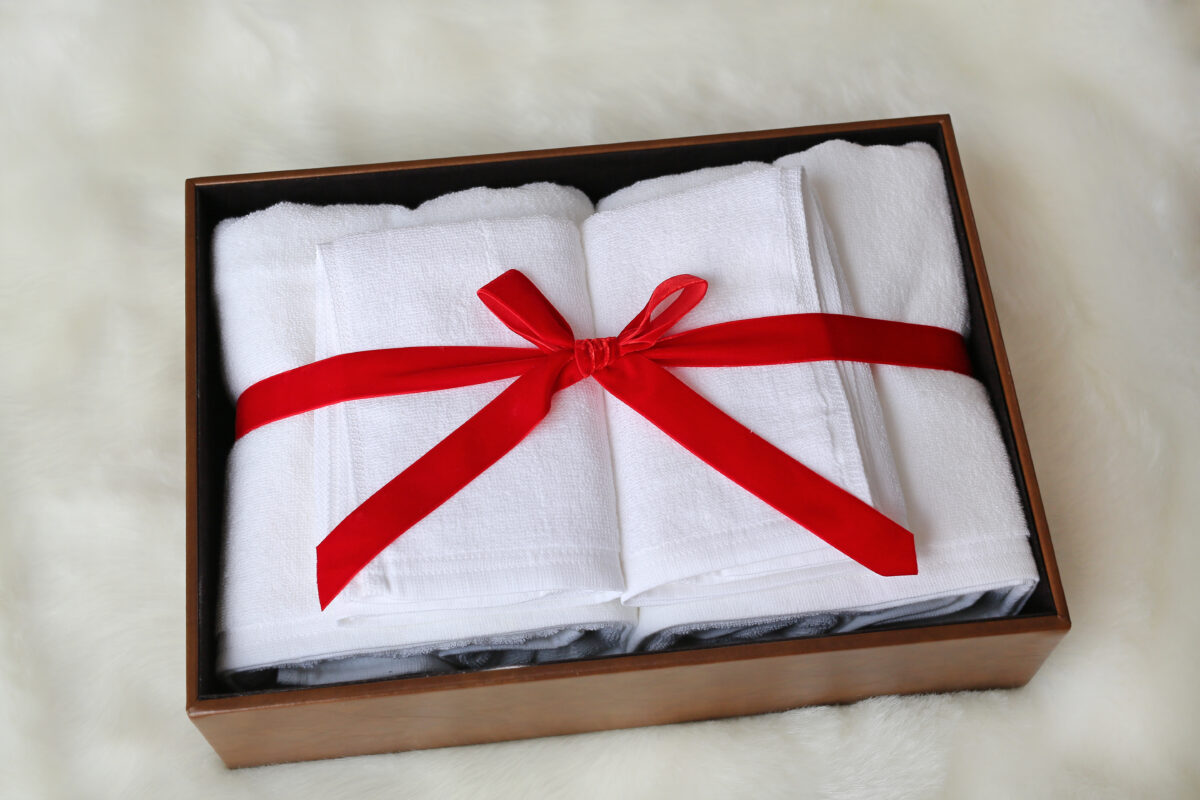 White towel gift in leather box on artificial fur background